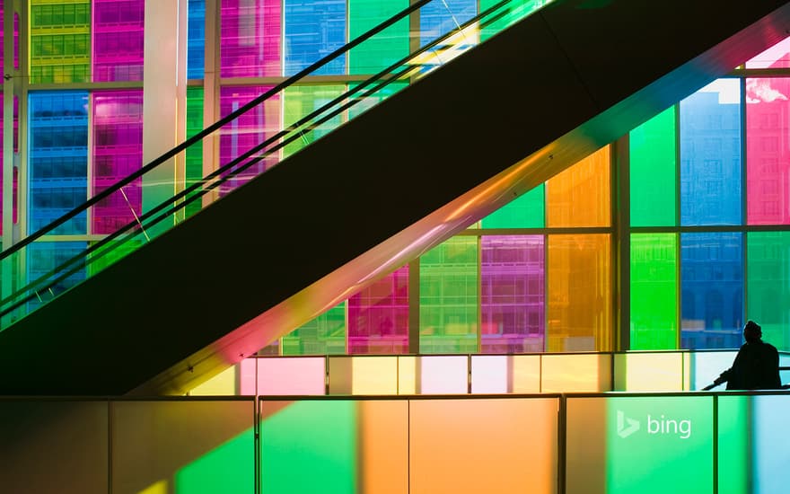 Silhouetted man standing in front of multi-coloured glass windows of Montreal's Palais des Congres Montreal, Quebec, Canada